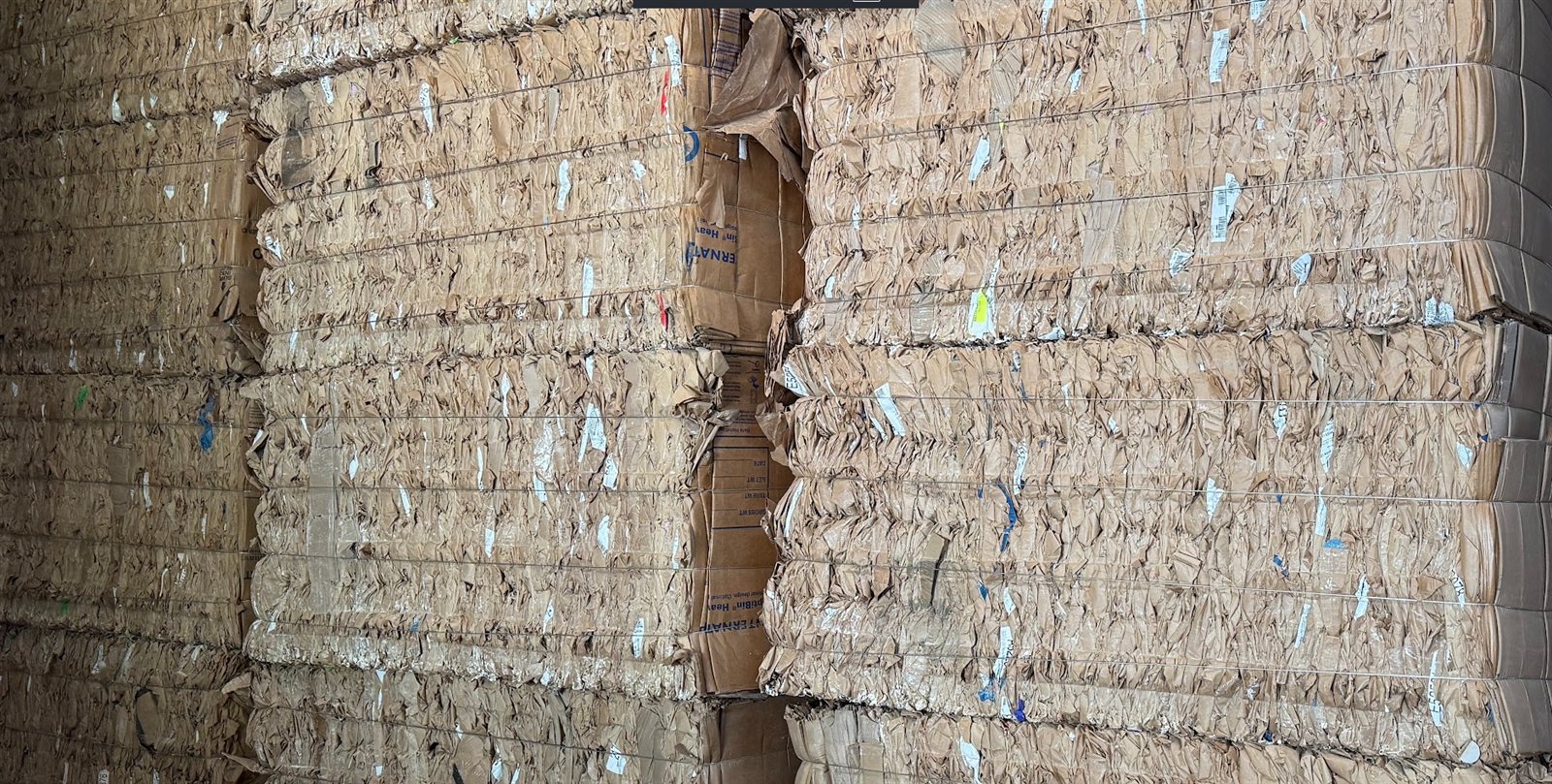 Stacked bales of recovered corrugated fiber